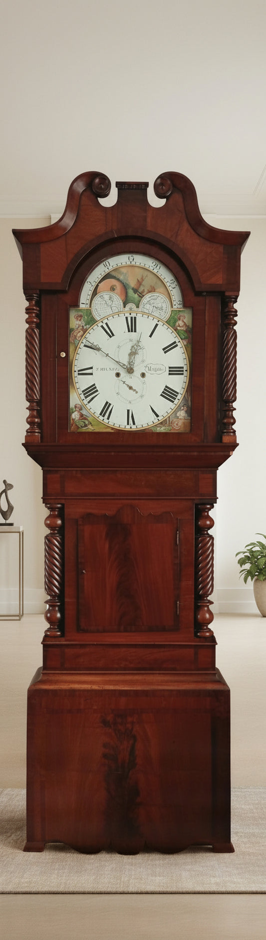 A flame mahogany grandfather clock with a painted dial, featuring intricate carvings and a swan neck with carved scrolls.